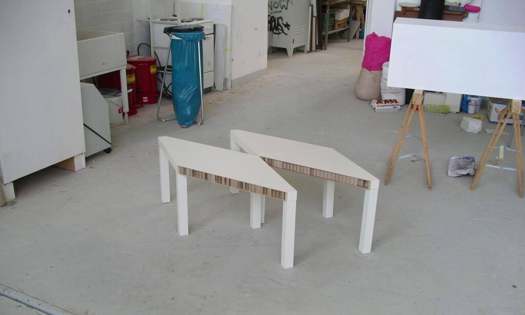 Zwei weiße Tische als verschobene Paarform im Atelier, Möbelobjekt von Roman Lindebaum.