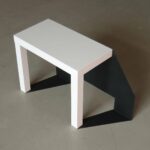 Tischobjekt mit schwarzem Volumen und weißer Platte, Untersuchung von Form, Funktion und Schatten.